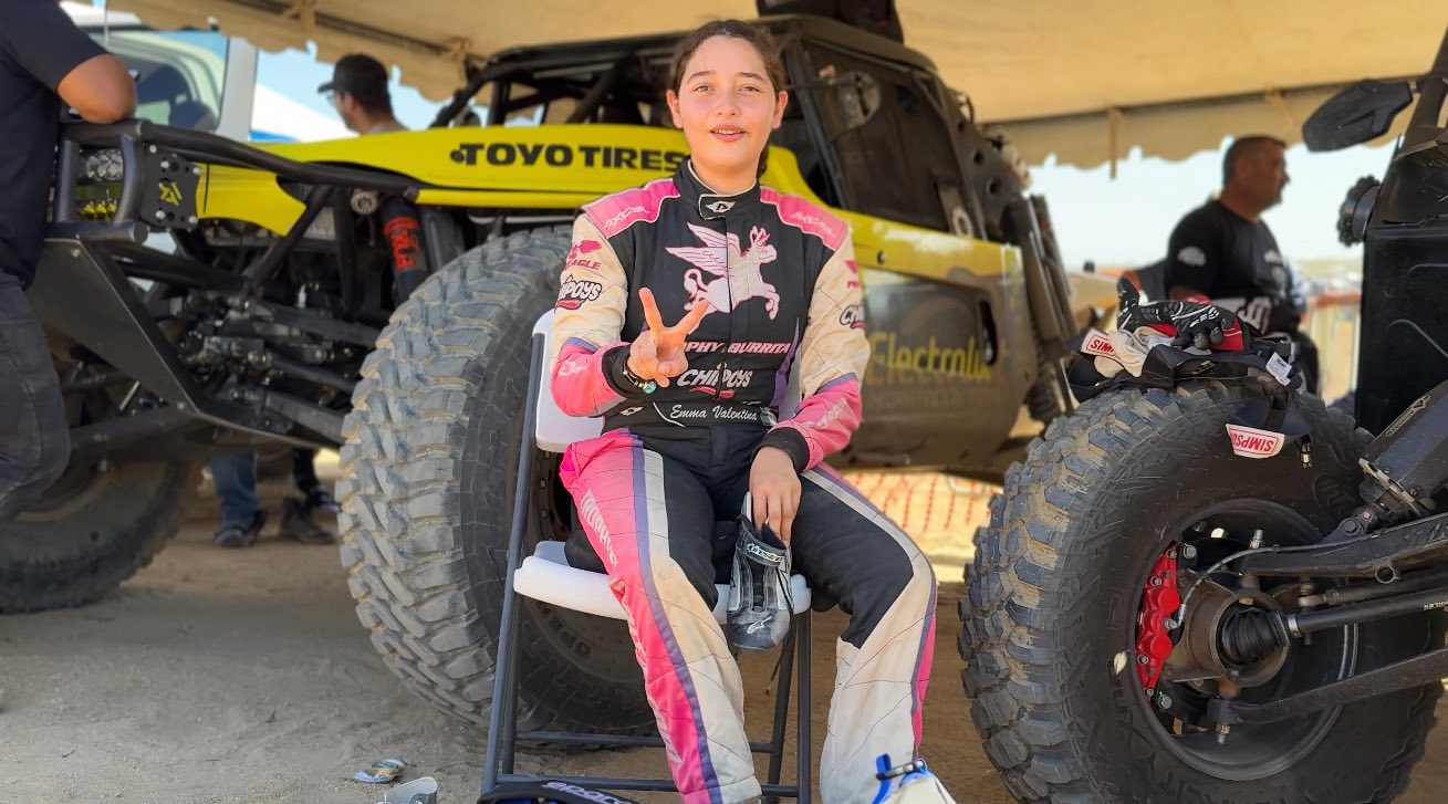 Emma Valentina Flynn out of her helmet at the track in her race suit.